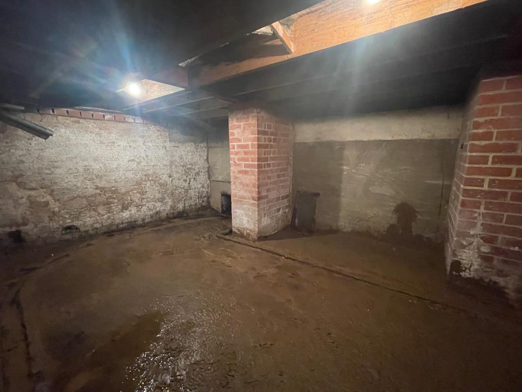 Lot: 50 - VACANT CITY CENTRE COMMERCIAL PREMISES WITH FORMER RESIDENTIAL USE ABOVE - Basement with stream running through it